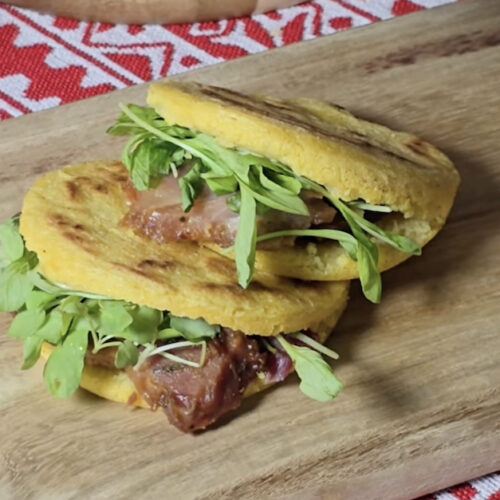 Arepas de harina de maíz rellenas con jamón y arúgula